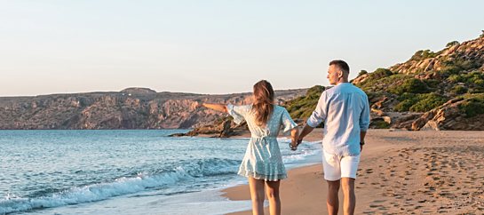 Happy Couple Walking On The Beach On The Sand