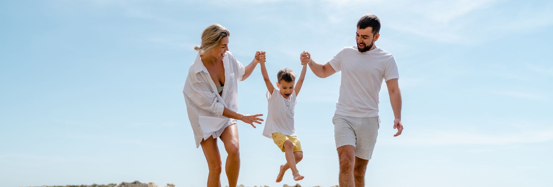 Happy Family Enjoys A Fun Walk Along The Sea