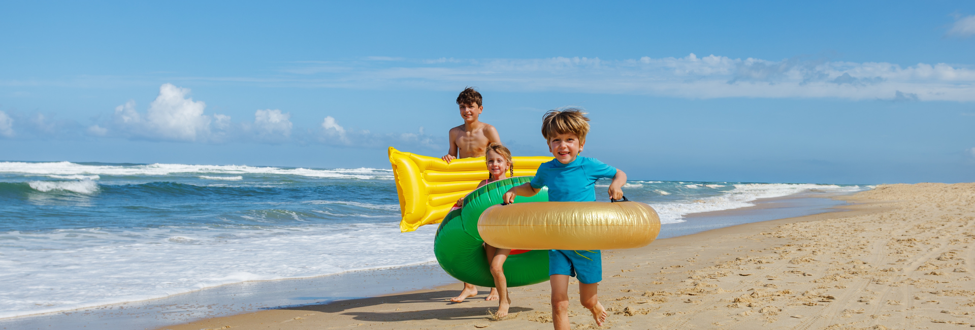 Three Children Are Running Happily Along The Beach
