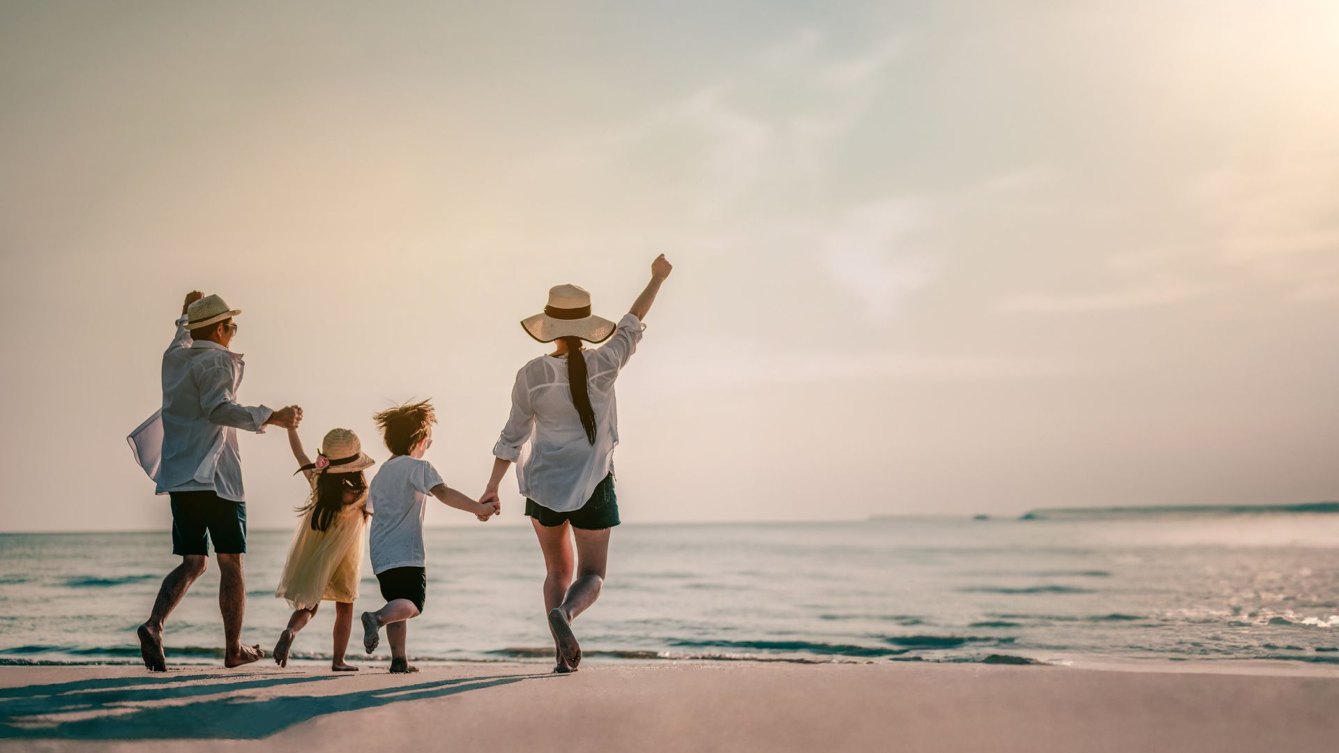 Happy Family Walking In The Sand At The Seashore