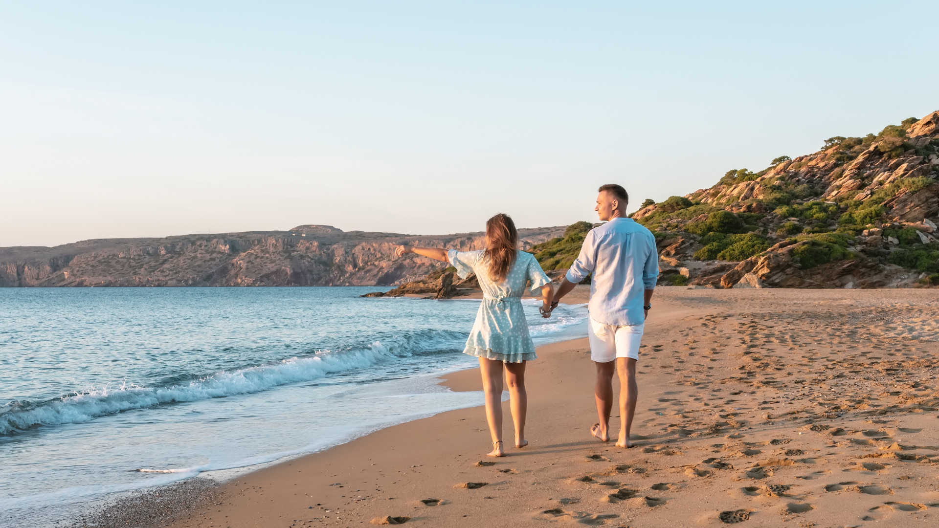 Happy Couple Walking On The Beach On The Sand