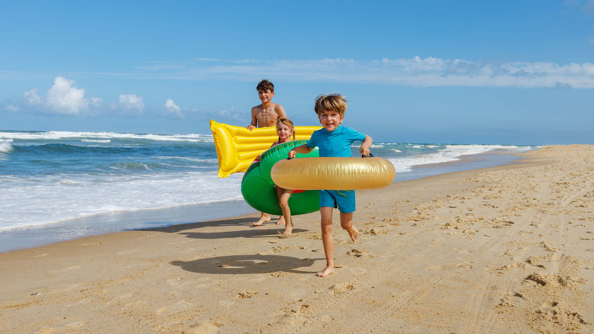 Three Children Are Running Happily Along The Beach