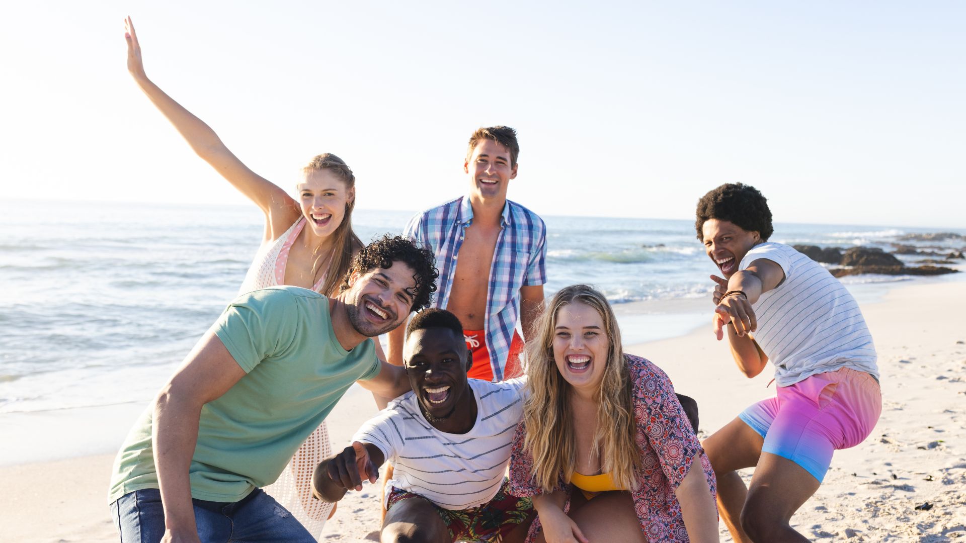 Several Groups Of Friends Enjoying A Day At The Beach