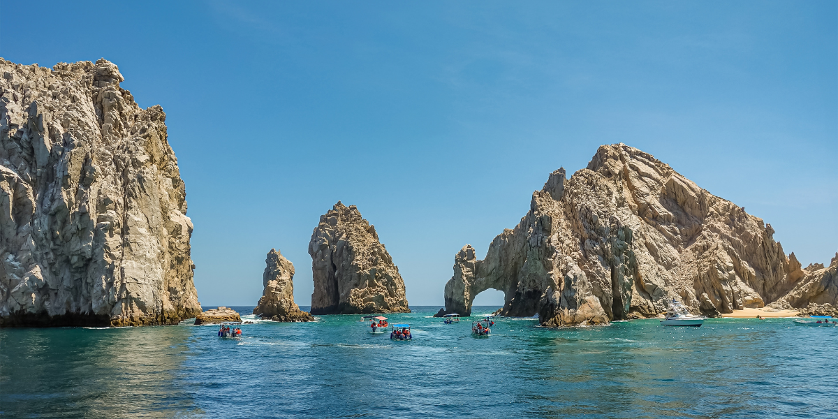 Small boat tour approaching El Arco (The Arch) in Cabo San Lucas, Mexico on a clear day