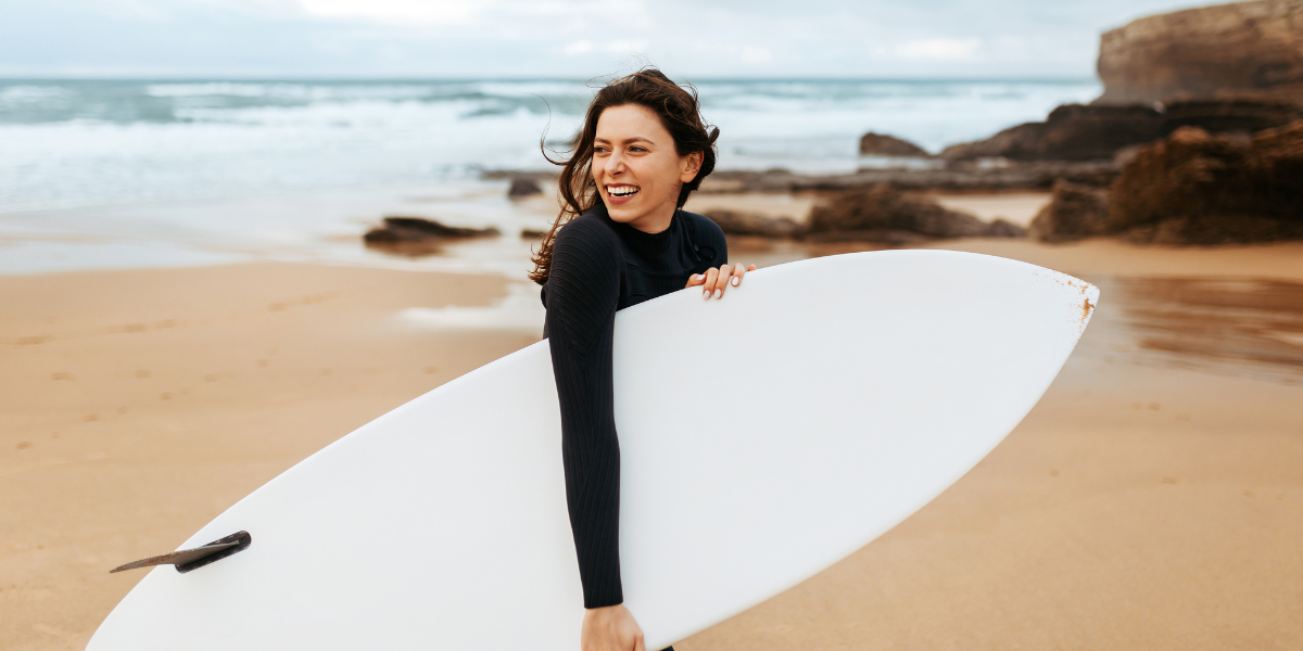 Beaches for surfing in Los Cabos Young woman with a surfboard on the beach