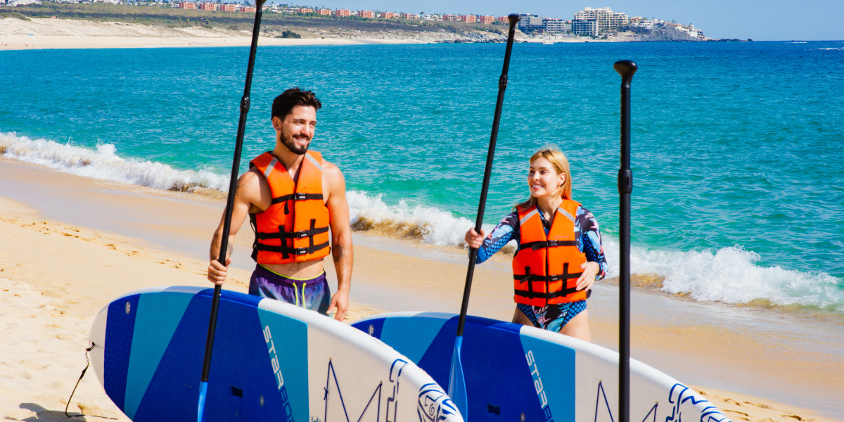pareja de vacaciones en la playa de Los Cabos para practicar paddleboard