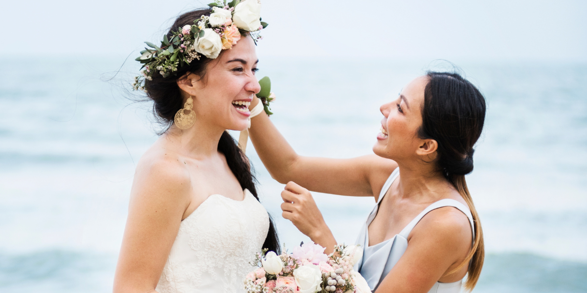 A bridesmaid and the bride smiling happily