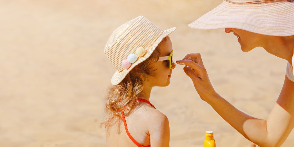 A mother applying sunscreen to her mom at the beach