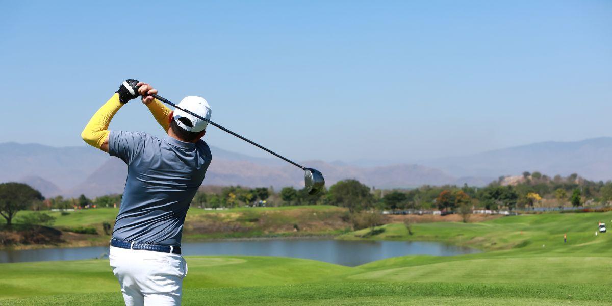 Hombre practicando en un gran campo de golf